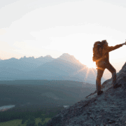 image of someone helping another person climb a mounting